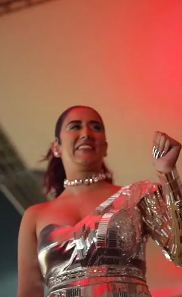 Jonita Gandhi performing at the TATA IPL 2023 finale, hair pulled back for the stage
